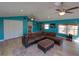Open living room with a large sectional couch, a ceiling fan, and natural lighting at 103 W Maple St, Davenport, FL 33837