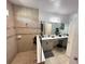 An elegant bathroom includes a dual vanity and tiled shower at 1220 Hilltop Pl # 1220, St Cloud, FL 34772