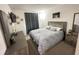 This cozy bedroom has a TV, picture frames, and a queen bed with gray bedding at 1220 Hilltop Pl # 1220, St Cloud, FL 34772