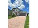 Two-story home with brick driveway, a two-car garage and manicured landscaping at 1220 Hilltop Pl # 1220, St Cloud, FL 34772