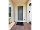 Home's front door has a grey door with a front porch and brick pavers at 1220 Hilltop Pl # 1220, St Cloud, FL 34772