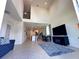 Open-concept living room showcasing soaring ceilings, tile flooring, and seamless flow to the kitchen at 1220 Hilltop Pl # 1220, St Cloud, FL 34772