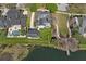 Drone shot features a house with solar panels, a spacious backyard, and waterfront access with a dock at 1251 Aquila Loop, Celebration, FL 34747