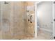Walk-in shower features glass doors, rain shower head, and stone look tile from floor to ceiling at 1251 Aquila Loop, Celebration, FL 34747