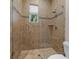Walk-in shower with tan tile, glass door, window and bronze fixtures at 1251 Aquila Loop, Celebration, FL 34747