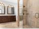 A full bathroom features double vanity, walk-in shower with glass doors, and stone look tile at 1251 Aquila Loop, Celebration, FL 34747