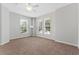 Spacious carpeted bedroom with three windows, ceiling fan and neutral paint at 1251 Aquila Loop, Celebration, FL 34747