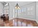 Charming dining room featuring hardwood floors, natural light, decorative chandelier, and adjacent living area at 1251 Aquila Loop, Celebration, FL 34747