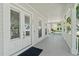 Inviting front porch with white columns, swing, and double doors enhancing curb appeal and providing a welcoming entry at 1251 Aquila Loop, Celebration, FL 34747