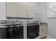 A well-organized laundry room with cabinets, countertop, and modern washer and dryer at 1251 Aquila Loop, Celebration, FL 34747