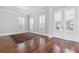 Bright living room featuring hardwood floors, white doors, and large windows with white shutters, creating a cozy atmosphere at 1251 Aquila Loop, Celebration, FL 34747