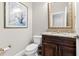 Charming powder room features a vanity, granite countertop, and decorative mirror at 1251 Aquila Loop, Celebration, FL 34747