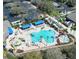 Aerial view showcasing the community pool, sun loungers, palm trees, and surrounding amenities at 1336 Lattimore Dr, Clermont, FL 34711