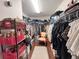 Spacious walk-in closet with custom shelving, organization and chair with a patterned rug at 1336 Lattimore Dr, Clermont, FL 34711