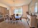 Bright dining room with a chandelier, large window, and neutral decor. Traditional style at 1336 Lattimore Dr, Clermont, FL 34711