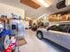Messy two car garage featuring overhead storage, car, and lots of boxes at 1336 Lattimore Dr, Clermont, FL 34711