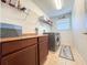 Functional laundry room with dark wood cabinets, shelves, a large window, and modern washer and dryer at 1336 Lattimore Dr, Clermont, FL 34711