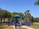 Community playground featuring colorful equipment, picnic tables, and a surrounding fence for safety at 1336 Lattimore Dr, Clermont, FL 34711