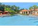 Large community pool surrounded by swaying palm trees, sun umbrellas, and lounge chairs; perfect for relaxation at 1370 Tuscana Ln # 5406, Davenport, FL 33896