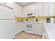 Clean kitchen featuring white cabinets, appliances, countertops, and hardwood floor at 1370 Tuscana Ln # 5406, Davenport, FL 33896