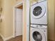 Convenient laundry area features a stacked washer and dryer unit and a white door entryway at 1370 Tuscana Ln # 5406, Davenport, FL 33896