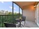 Relaxing screened patio area with table and chairs, offering scenic views of the surrounding lush landscape at 1370 Tuscana Ln # 5406, Davenport, FL 33896