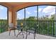 Screened patio area with chairs and table, overlooking lush greenery, perfect for relaxing and enjoying the outdoors at 1370 Tuscana Ln # 5406, Davenport, FL 33896
