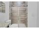 Bathroom boasts a shower with glass doors and stylish wood-look tile, plus updated fixtures at 139 Columbia Dr, Poinciana, FL 34759