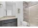 Bathroom featuring granite countertops, wood-look accent wall, and a glass-enclosed shower at 139 Columbia Dr, Poinciana, FL 34759