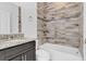 This bathroom features a shower-tub combination and vanity with granite countertops at 139 Columbia Dr, Poinciana, FL 34759