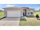 Inviting single-story home featuring a two-car garage, manicured lawn, and tasteful landscaping at 139 Columbia Dr, Poinciana, FL 34759