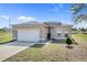 Charming single-story home with a well-maintained lawn and attached two-car garage at 139 Columbia Dr, Poinciana, FL 34759