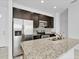 Modern kitchen features stainless steel appliances, dark cabinets, and speckled granite countertops at 139 Columbia Dr, Poinciana, FL 34759