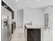 Modern kitchen with stainless steel appliances, dark cabinets, speckled granite countertops, and tile floors at 139 Columbia Dr, Poinciana, FL 34759