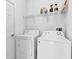 This laundry room includes a side-by-side washer and dryer, and an overhead storage shelf at 139 Columbia Dr, Poinciana, FL 34759