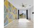 Living room features a modern accent wall, bright sliding glass doors, and tile flooring at 139 Columbia Dr, Poinciana, FL 34759