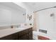 Bright bathroom features a single sink vanity with brown cabinets and shower-tub combo at 1431 Lassen St, Haines City, FL 33844