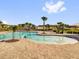 A lagoon style pool with zero entry, palm trees and lounge chairs in a community at 1431 Lassen St, Haines City, FL 33844