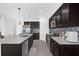 Modern kitchen boasts dark cabinetry, stainless steel appliances, a stylish backsplash, and a bright quartz countertop at 1431 Lassen St, Haines City, FL 33844