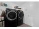 Modern laundry room with black, front load washer and dryer and white walls at 1431 Lassen St, Haines City, FL 33844