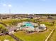 Aerial view of a community pool with palm trees, lounge chairs, and a covered seating area at 1431 Lassen St, Haines City, FL 33844