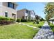 Street view showcasing a row of well-maintained townhomes with manicured lawns at 1615 Reflection Cv, St Cloud, FL 34771