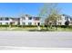 Street view showcasing a row of well-maintained townhomes and manicured lawns at 1615 Reflection Cv, St Cloud, FL 34771