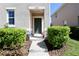 Close up of front entrance with muted exterior, green door, concrete steps, and landscaping at 1615 Reflection Cv, St Cloud, FL 34771