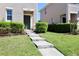 Inviting front entrance featuring a green door, concrete steps, and manicured shrubs at 1615 Reflection Cv, St Cloud, FL 34771
