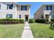 Charming townhome with a green door and lush landscaping leading to a well-kept lawn at 1615 Reflection Cv, St Cloud, FL 34771
