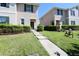 Charming townhome with a green door and lush landscaping leading to a well-kept lawn at 1615 Reflection Cv, St Cloud, FL 34771