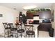 This kitchen features a light fixture, dark cabinets, granite countertop, tile flooring, and a black refrigerator at 1615 Reflection Cv, St Cloud, FL 34771