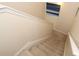 Neutral carpeted staircase with beige walls and a painting on the wall at 1615 Reflection Cv, St Cloud, FL 34771