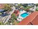 Overhead view of the sparkling blue community pool and hot tub, with lounge seating and mature palm trees at 1631 Little Falls Cir # 92, Orlando, FL 32807